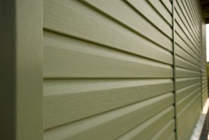 Close-up of olive green vinyl house siding